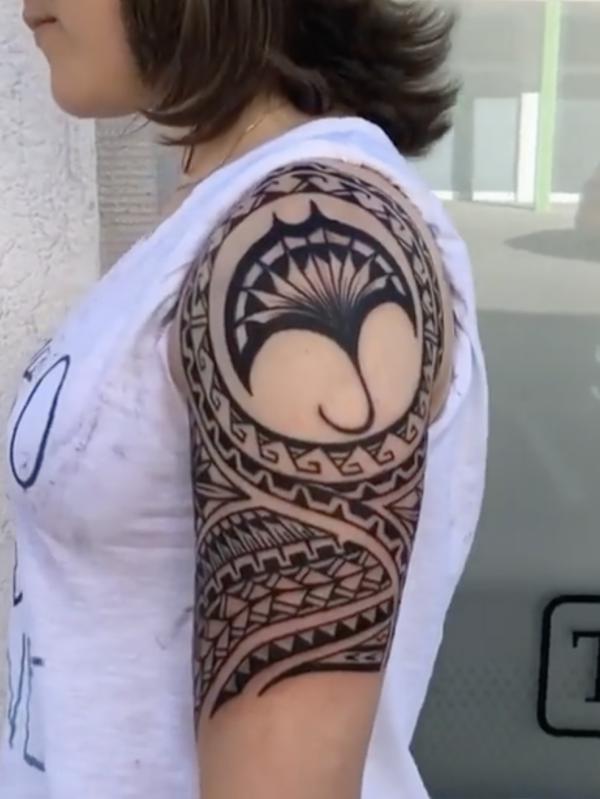Tribal upper arm tattoo with flowe