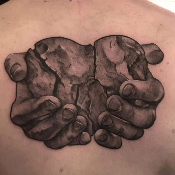 Two hands holding a broken heart tattoo