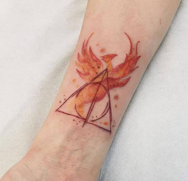 Watercolor deathly hallows and phoenix tattoo on inner forearm