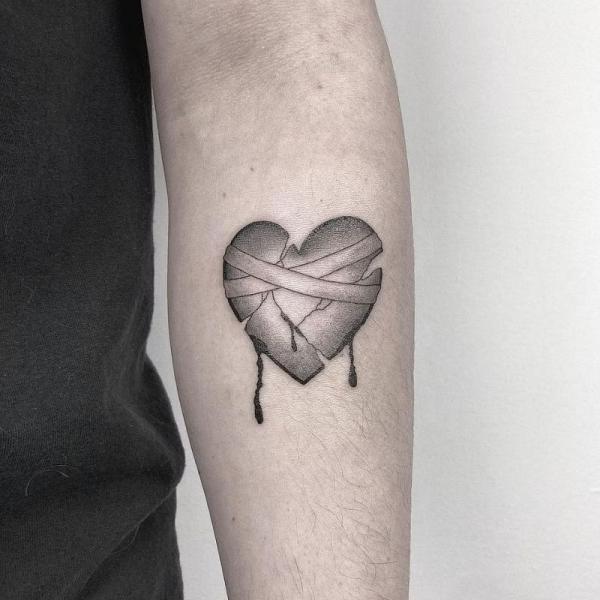 bandaged broken heart tattoo black and grey