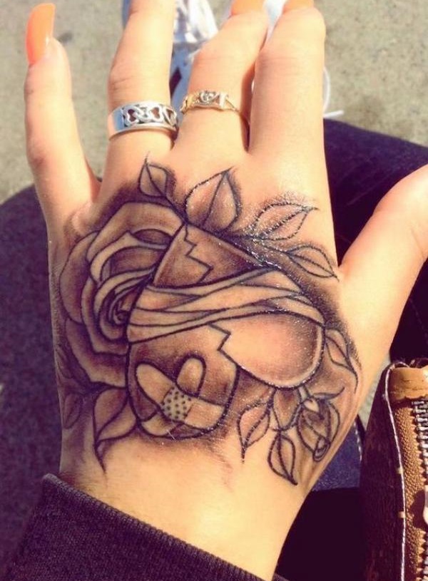broken heart with rose and bandaid hand tattoo