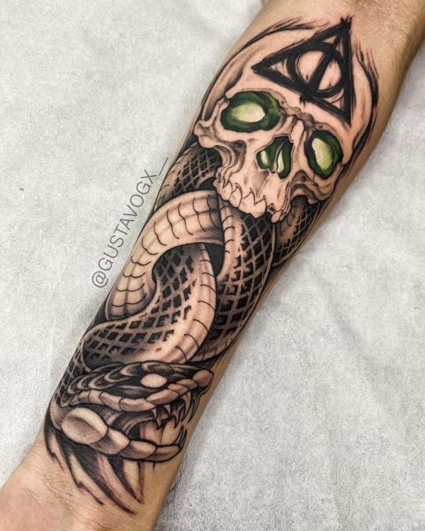 death eater with deathly hallows tattoo on forearm