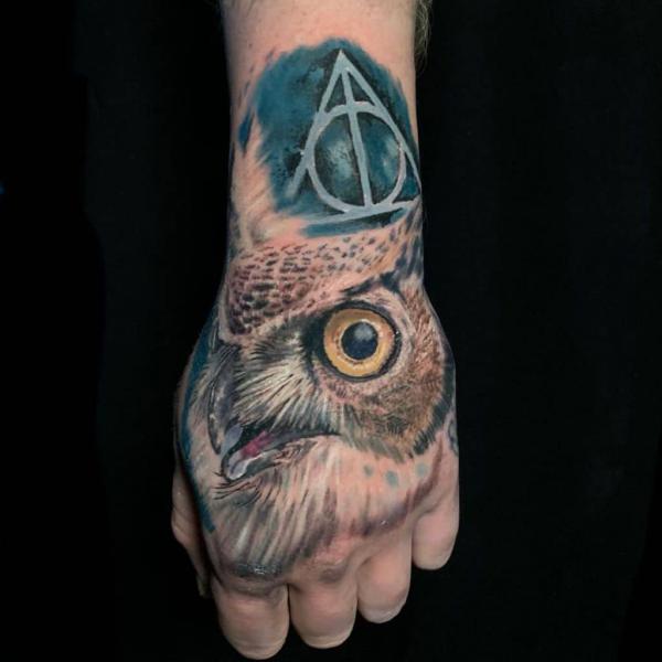 deathly hallows and realistic owls head hand tattoo