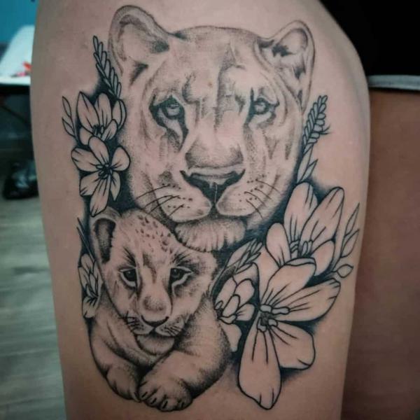 lioness and cub flower thigh tattoo