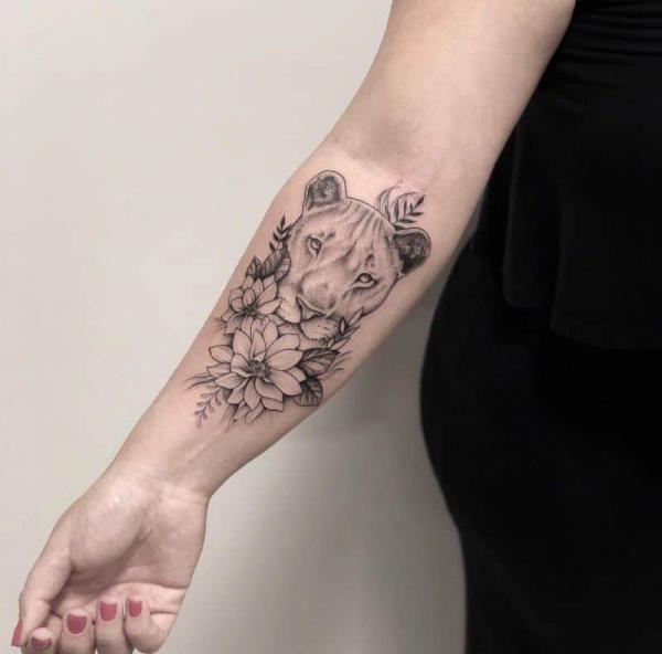 lioness and flower inner forearm tattoo