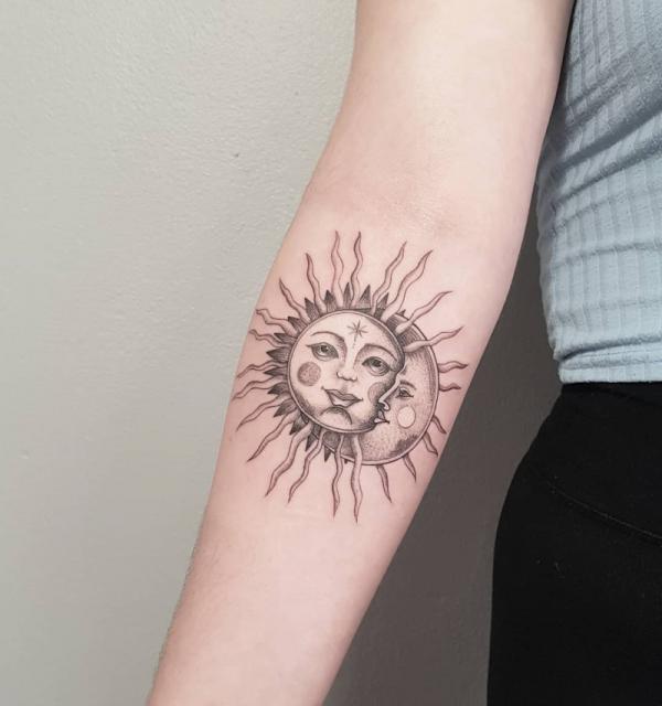 sun and moon smiling face forearm tattoo