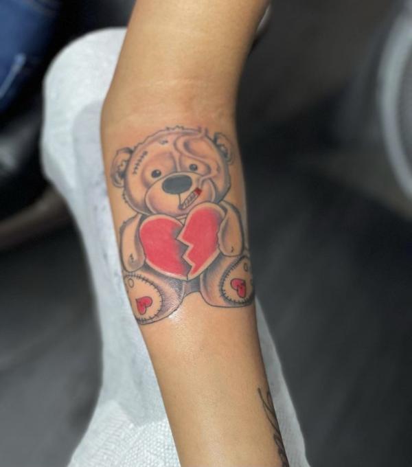 teddy bear holding a broken heart tattoo