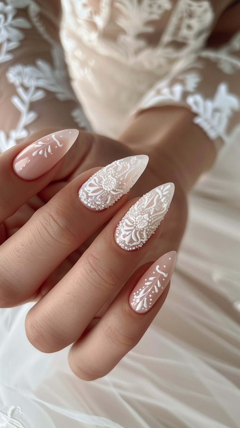 Stiletto nails with a nude base adorned with white lace detailing, creating an elegant and sophisticated bridal nail art design.
