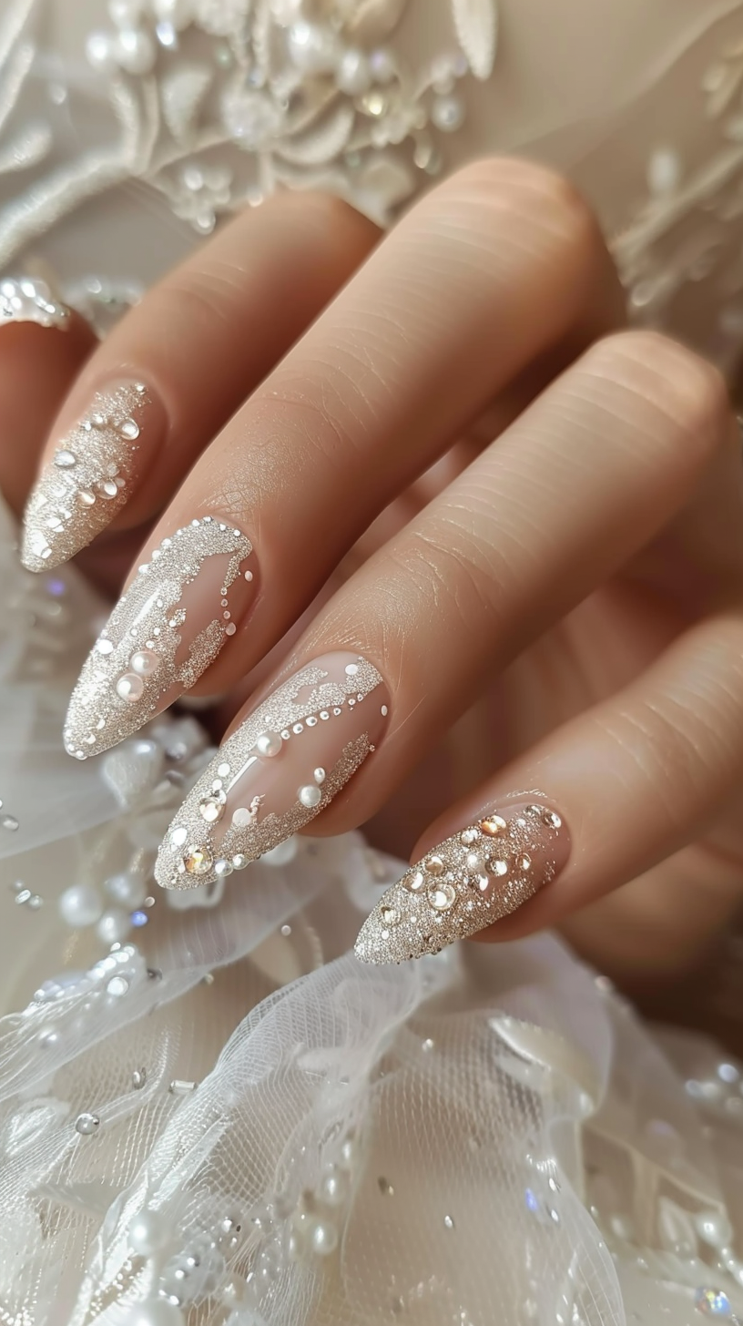 Almond nails with a nude base, elegantly embellished with white dots and gold glitter, resembling sparkling dew on a morning vine.