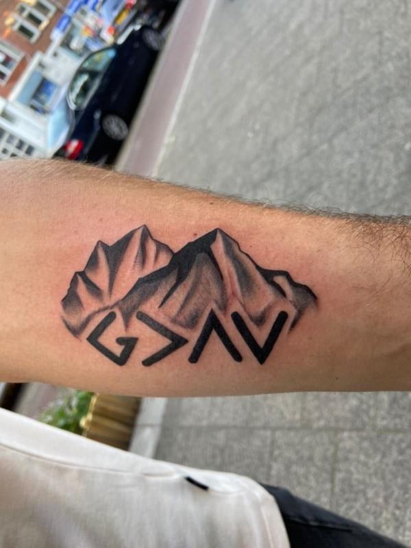 god is greater than the highs and lows with mountain tattoo forearm