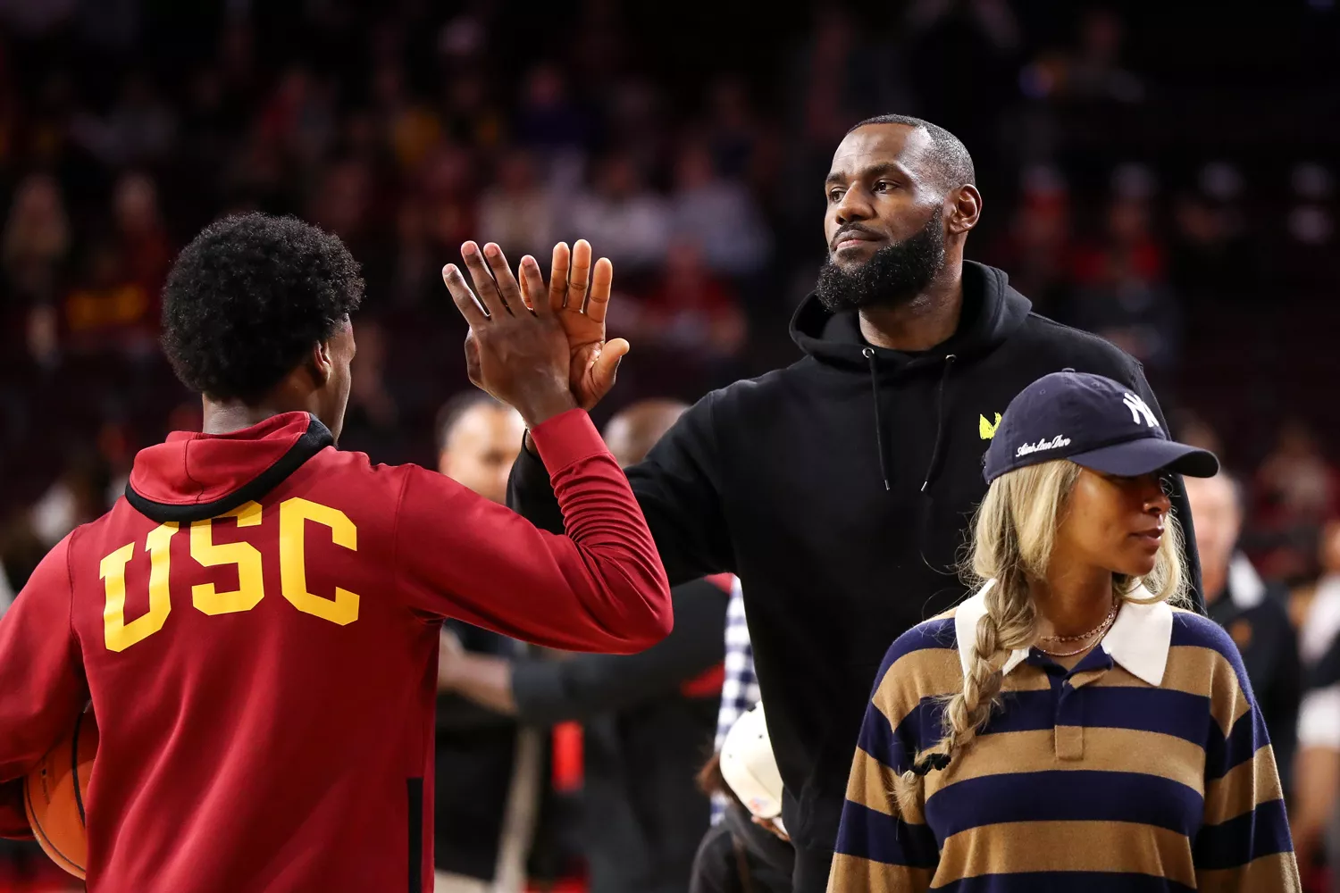 Bronny James #6 of the USC Trojans greets his dad, LeBron James of the Los Angeles Lakers, before the game against the Stanford Cardinal at Galen Center on January 06, 2024 in Los Angeles, California. 