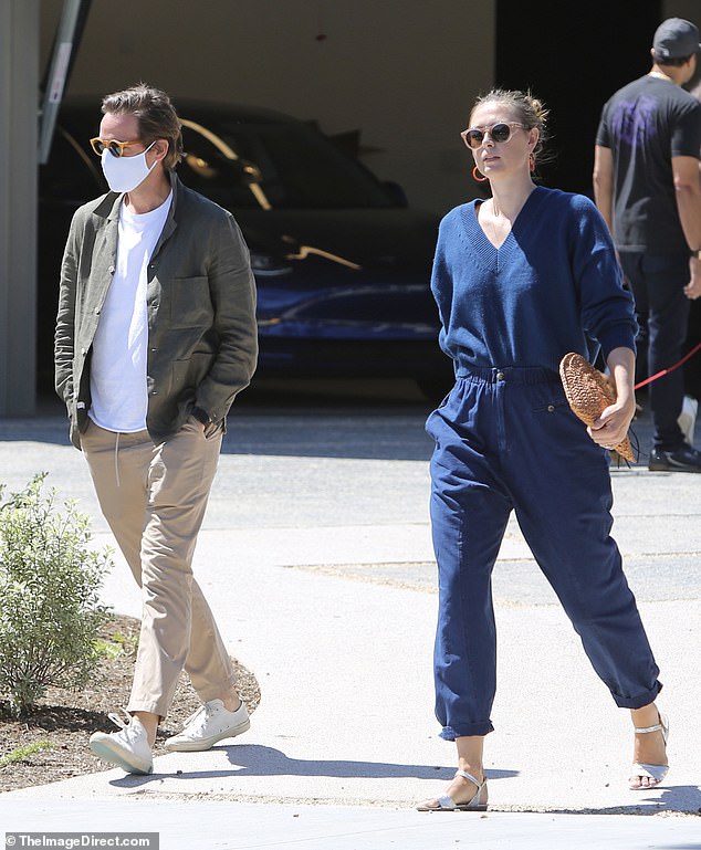 Chic: Maria accessorized her indigo attire with Dries Van Noten sandals, pink sunglasses, and a fan-shaped, star-spangled clutch