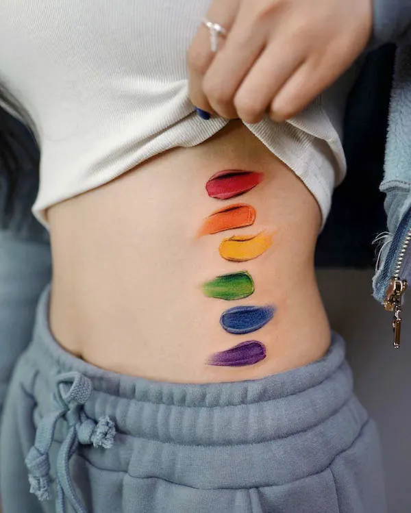 Realism rainbow paint stroke waist tattoo by @tattoo_a_piece