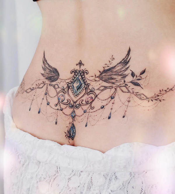 Gemstone angel wings tattoo on the lower back by @tattooist_jammy.j