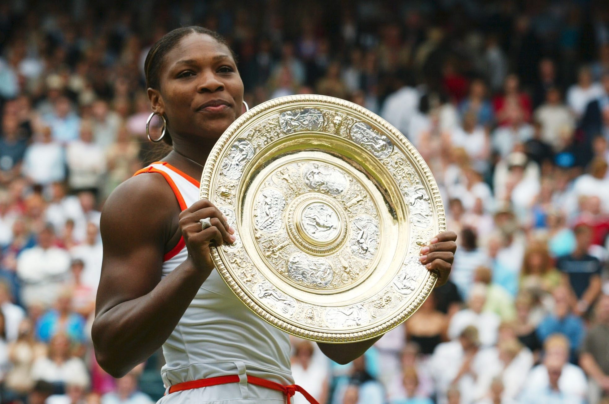 Serena Williams presents her trophy to the crowd after securing her victory in the Women's Singles Final of the Wimbledon Lawn Tennis Championships on July 5, 2003, in London, England.