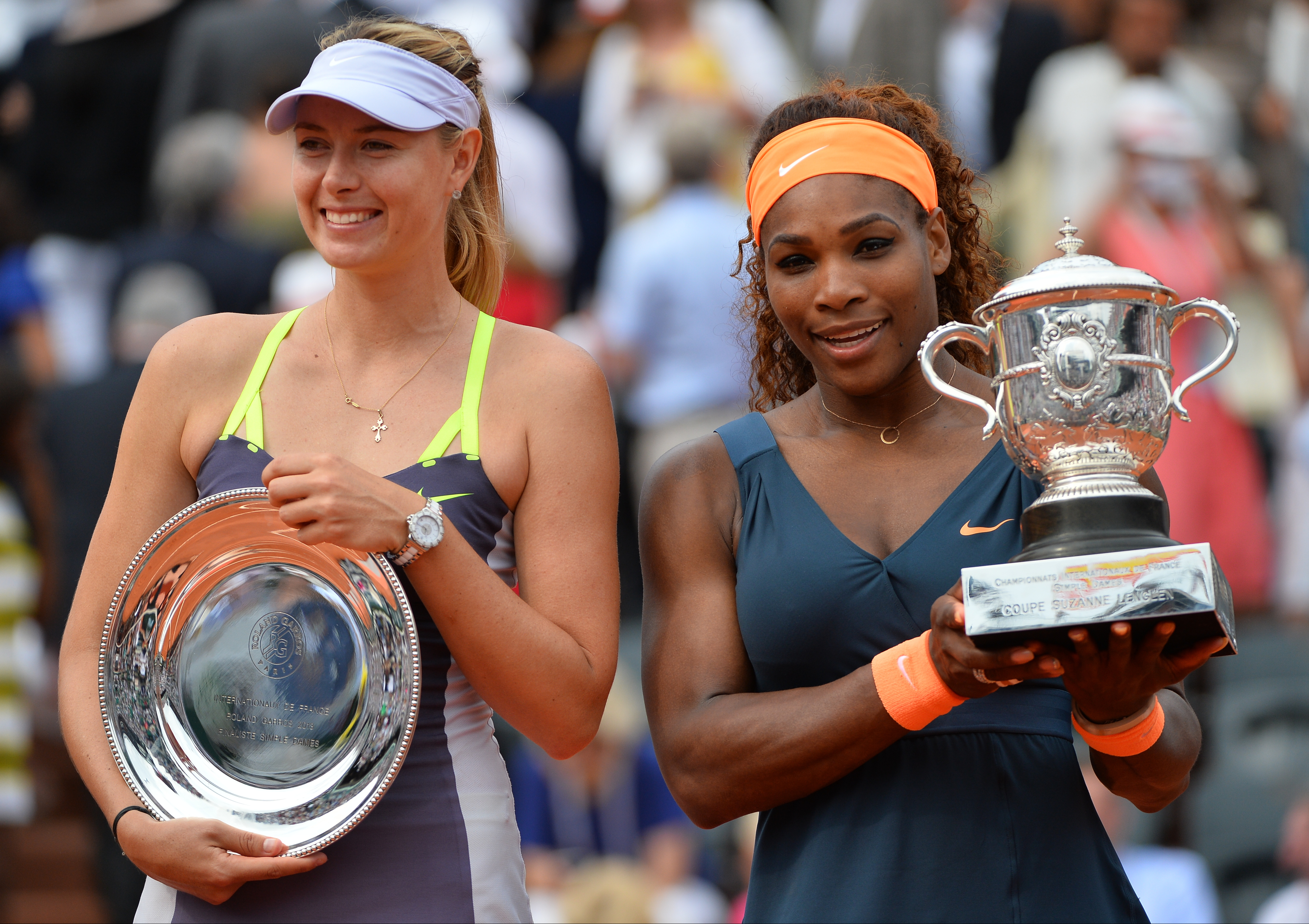 Serena Williams takes a photo with her trophy after defeating Russia's Maria Sharapova (left) in the Women's Final of the French Tennis Open 2013 at Roland-Garros Stadium in Paris, France on June 8, 2013.