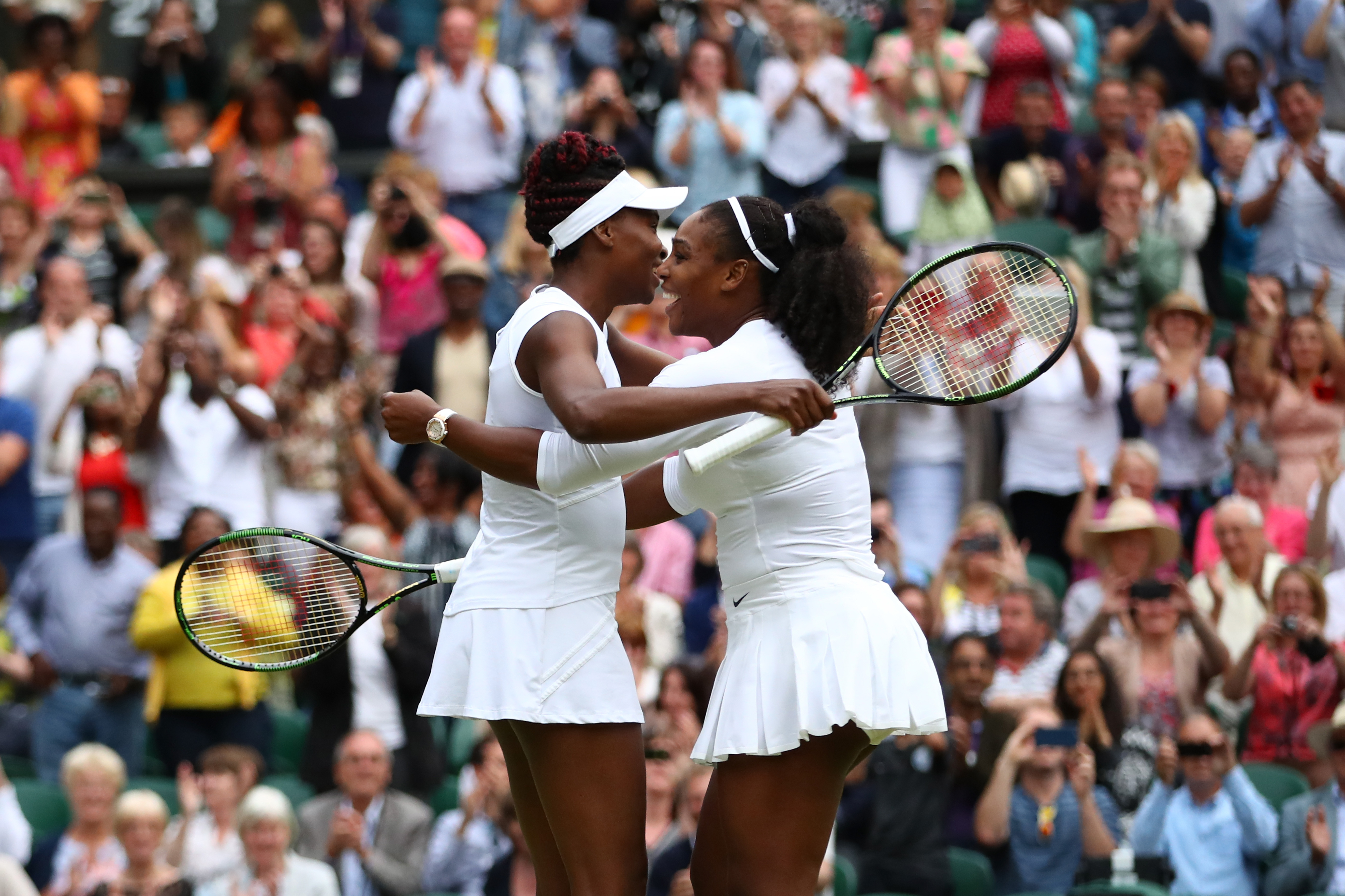 Serena and Venus Williams embrace each other after a victory in their Ladies Doubles Final of the Wimbledon Lawn Tennis Championships on July 9, 2016, in London, England.