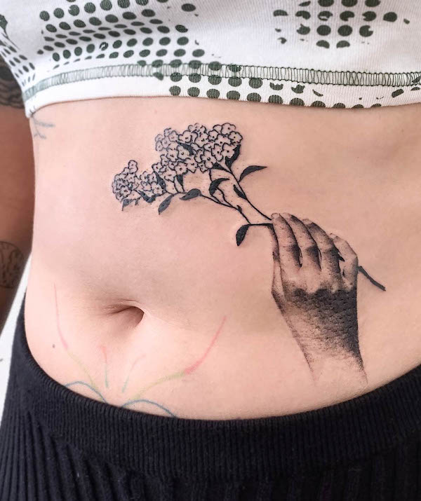 Hand with flower waist tattoo by @lucyctattoos