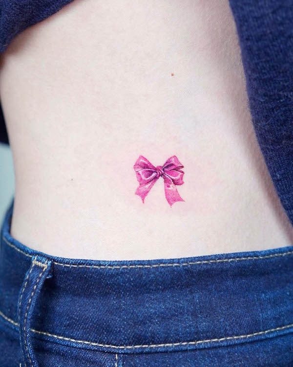 Small ribbon waist tattoo by @tilda_tattoo