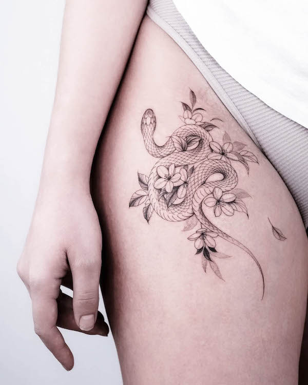 Snake and cherry blossom thigh tattoo by @la_source_tattoo