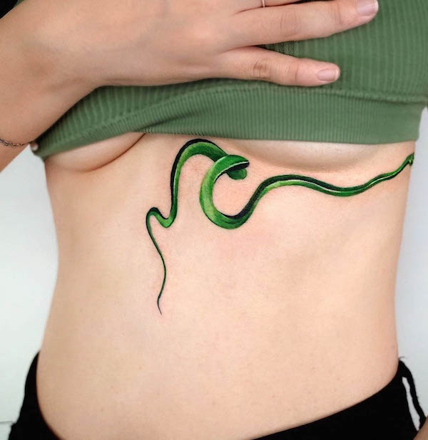 Captivating green snake under boob by @soosoo.tattoo