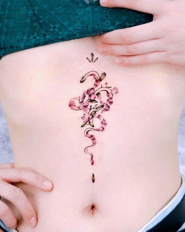 Floral snake underboob tattoo by @hwyl.tattoo