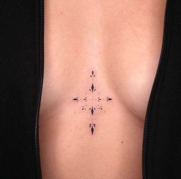 Minimalist ornamental underboob tattoo by @zahaitattoo