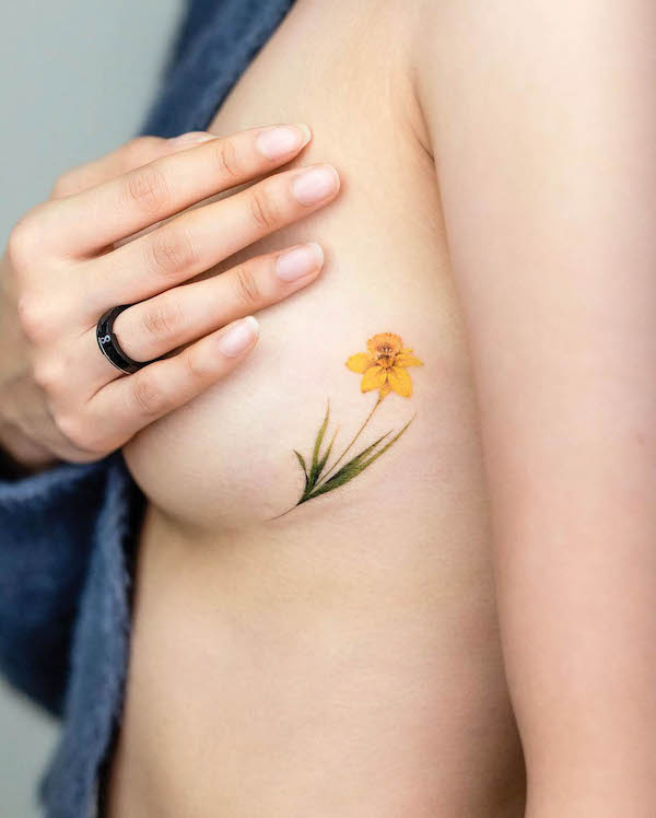 Small yellow flower side tattoo by @pokhy_tattoo