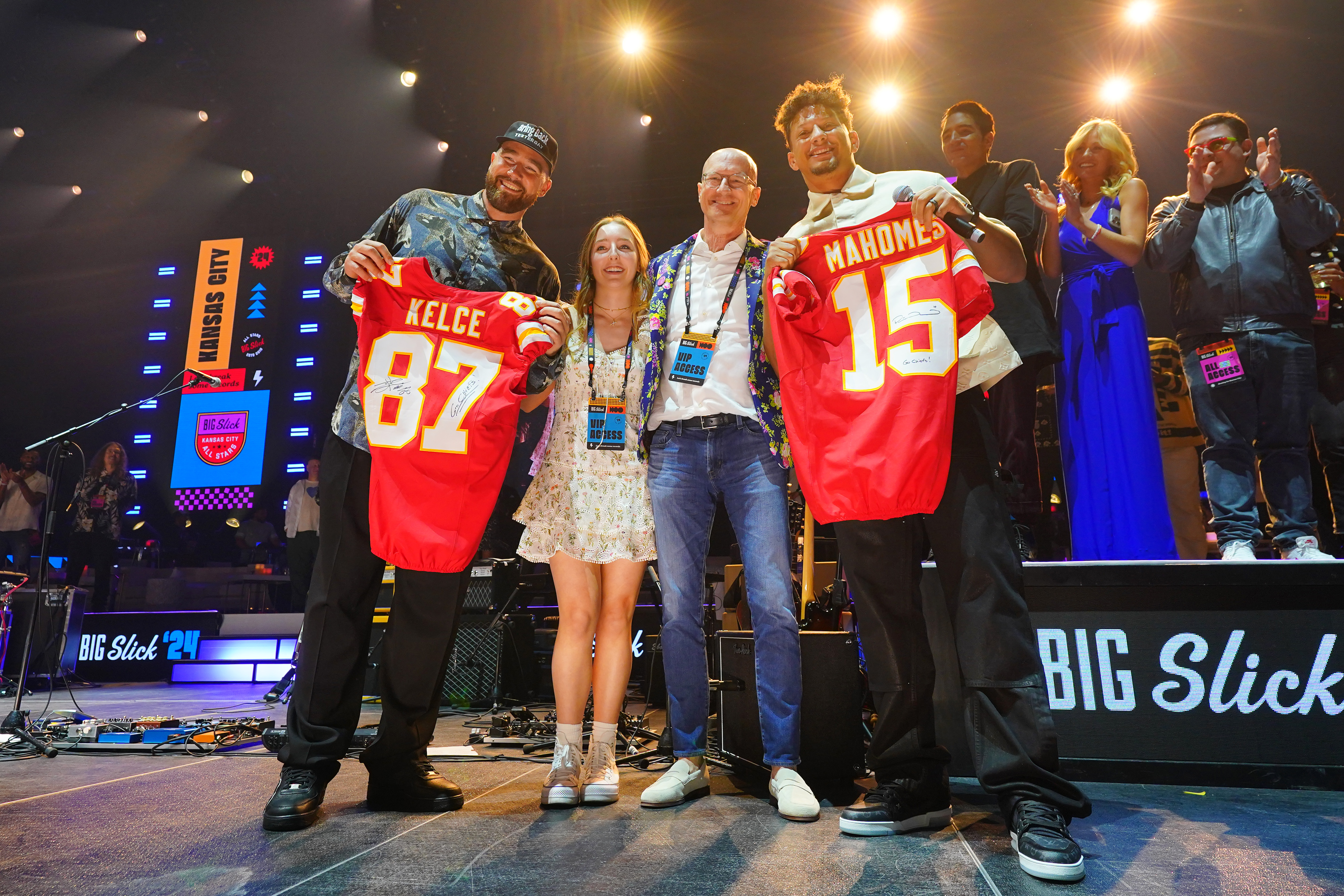 Travis Kelce (L) and Patrick Mahomes (R) pose onstage with donors Katherine Schell and Brian Schell