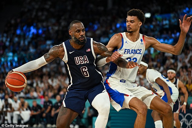 LeBron James bangs into the lane against France's Victor Wembanyama in the Olympic final