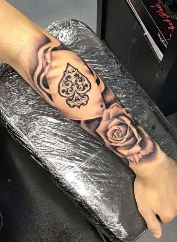 Black and grey ace of spades and rose with smoke tattoo forearm